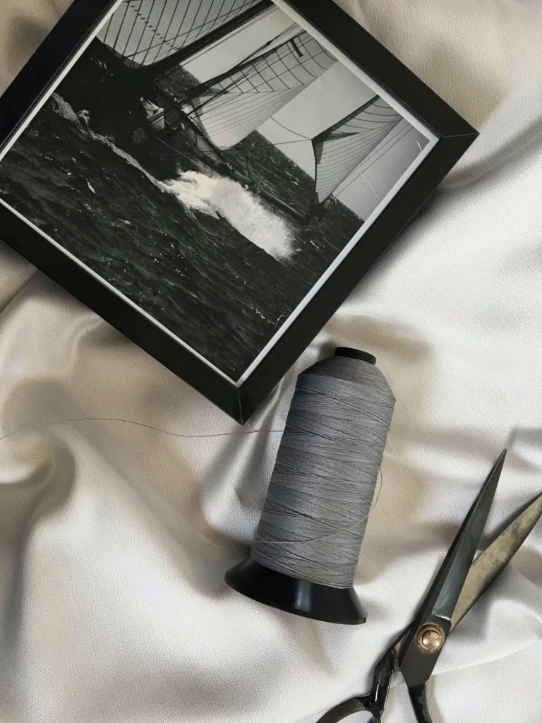 Black & white photo, scissors & thread reflecting passion, inspired by traditional craftsmanship & modern yacht trends.