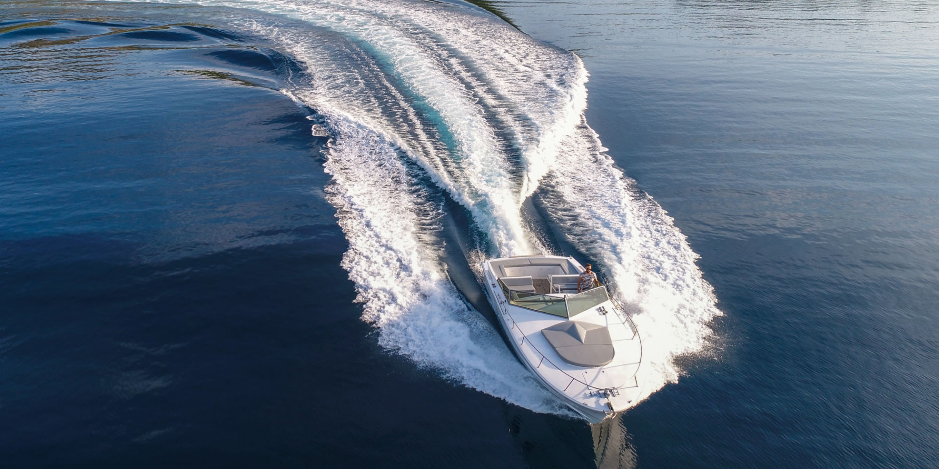 A tornado boat in Hvar with customised silver metallic yacht exterior cushions and a sundeck cushion shaped like a compass rose made by Frey.