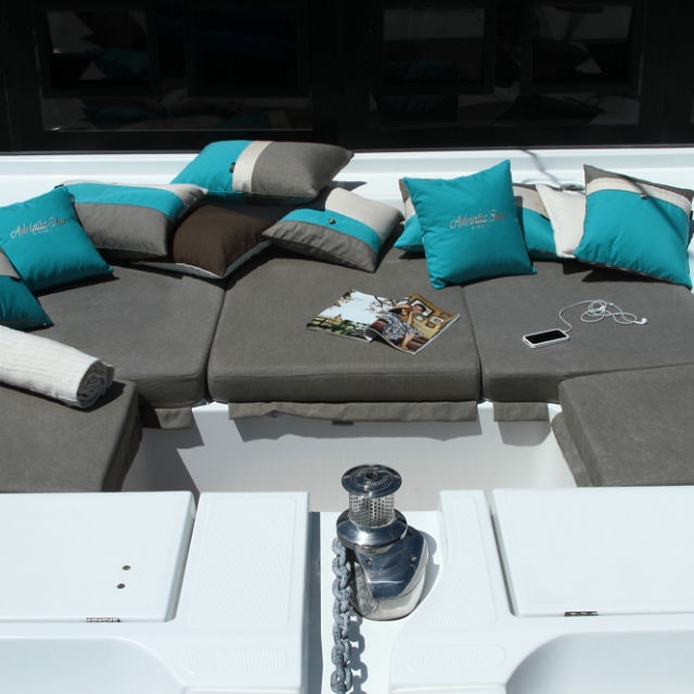 Complete re-upholstered forward deck cushions for Lagoon 52 F catamaran. Grey with decorative turquoise Frey luxury pillows.