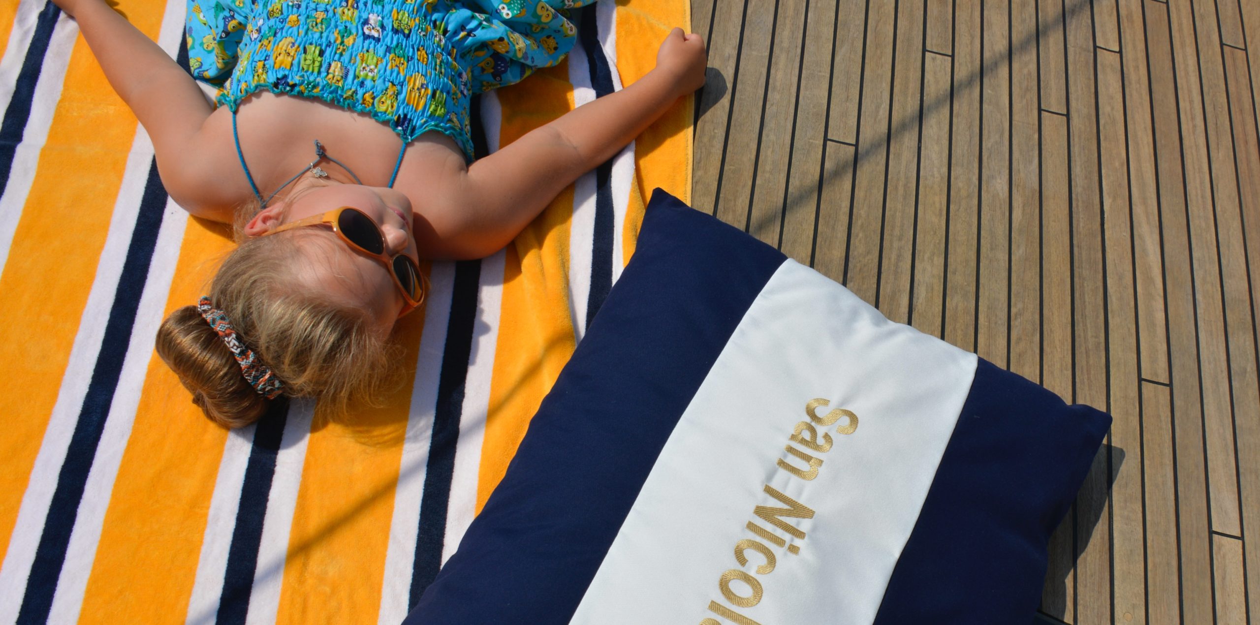 Embroidered Frey Luxury Pillows with yacht name San Nicola. A perfect yacht decor for a child's nap after a swim or sailing.