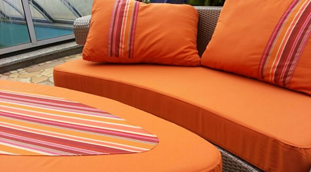 Frey, rich spectrum of orange colour/stripe fabric garden cushions & pillows, near outdoor indoor pool, are water-repellent.