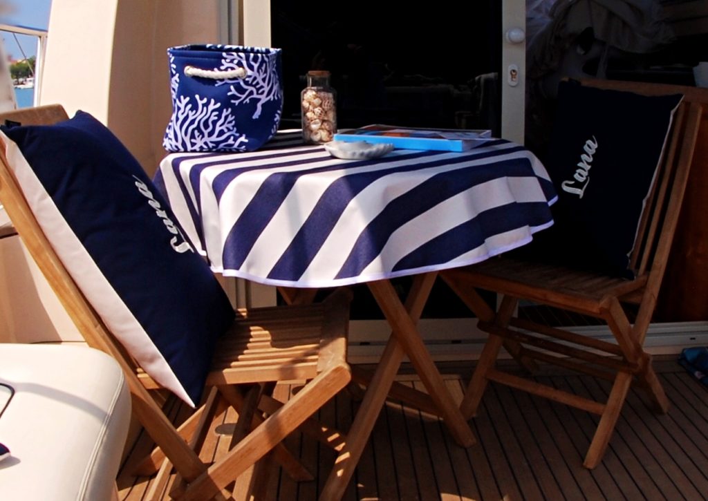 Yacht exterior deck area, bespoke blue & white tablecloth with personailsed & embroidered seahorse motif, Frey Luxury Pillows.