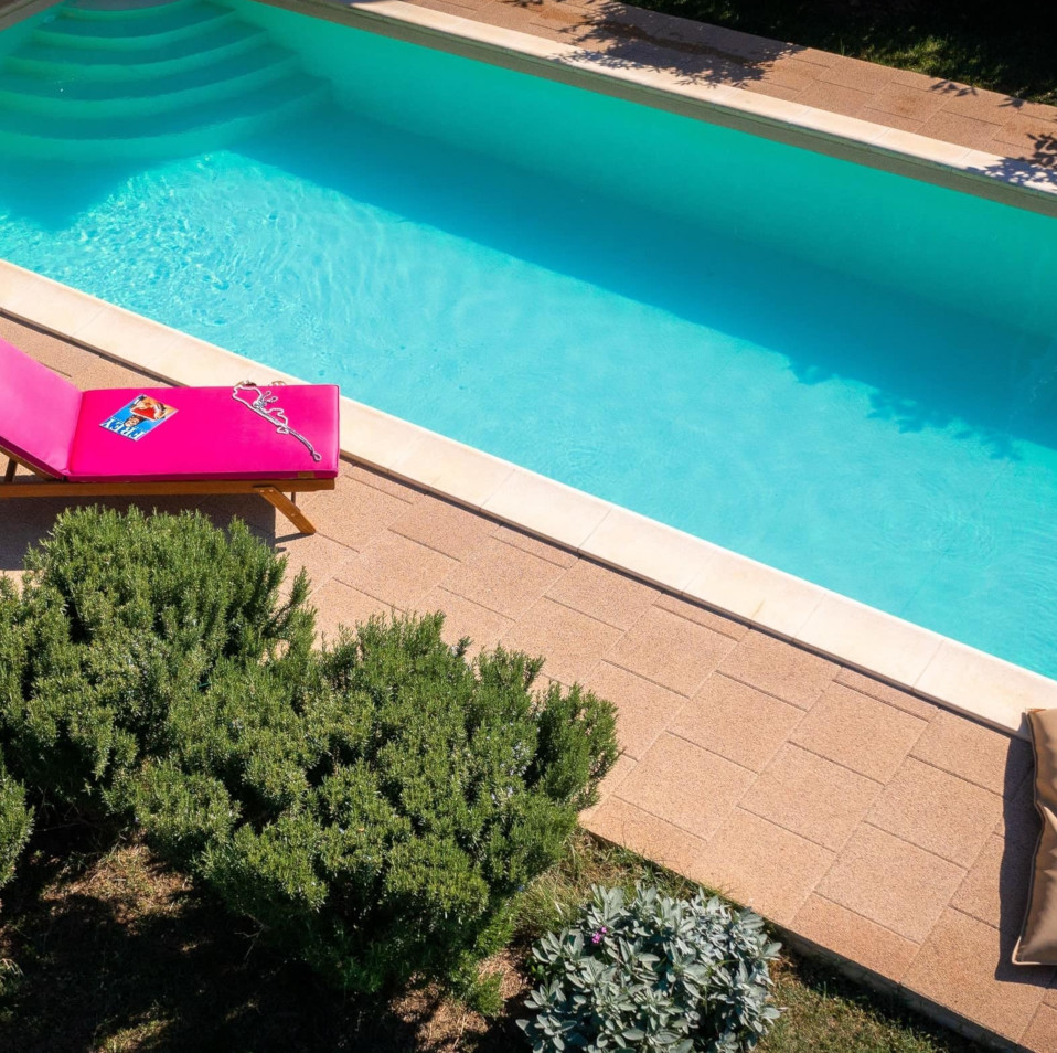 Luxury magenta sunbed poolside cushions for contemporary Villa Lu-Ma, in Sunbrella water-repellant fabric, handmade by Frey.